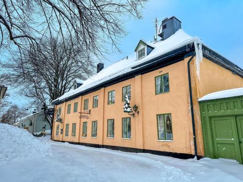 un edificio naranja con nieve encima en Säters Stadshotell en Säter