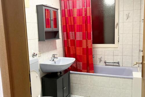 uma casa de banho com um lavatório e uma cortina de chuveiro vermelha. em Apartment in Neu-Ulm em Neu-Ulm