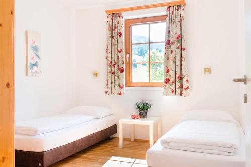 two beds in a room with a window at Stranach Appartements in Sankt Michael im Lungau