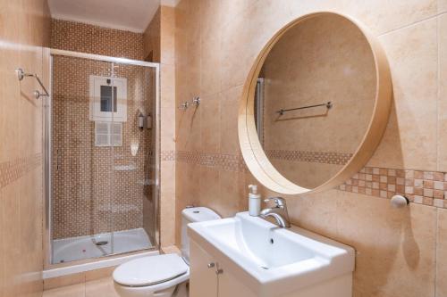 uma casa de banho com um WC, um lavatório e um espelho. em Eixample 7 em Barcelona
