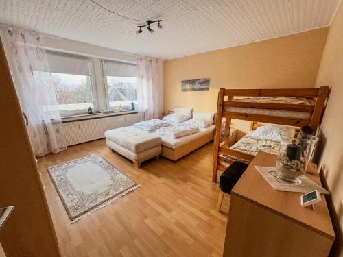 1 Schlafzimmer mit 2 Etagenbetten und einem Schreibtisch in der Unterkunft Ferienwohnung Ankommen & Wohlfühlen in Cuxhaven
