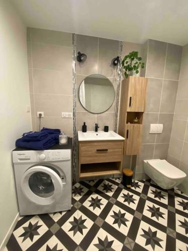 une salle de bain avec une machine à laver et un lave-linge dans l'établissement Charmant studio idéalement placé et paisible !, à Oloron-Sainte-Marie