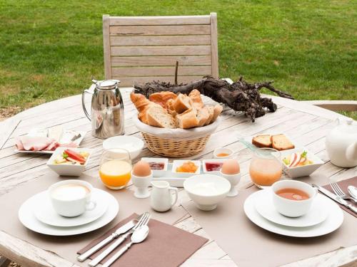 uma mesa de piquenique com uma cesta de pão e ovos em Château de Perreux, The Originals Collection em Amboise