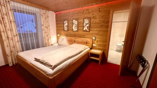 ein kleines Schlafzimmer mit einem Bett und einem Badezimmer in der Unterkunft Pension Schierl in Faistenau