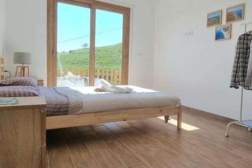 um quarto com uma cama e uma grande janela em Villa Ulivo a 900 metri dal Mare em Santa Caterina Dello Ionio Marina