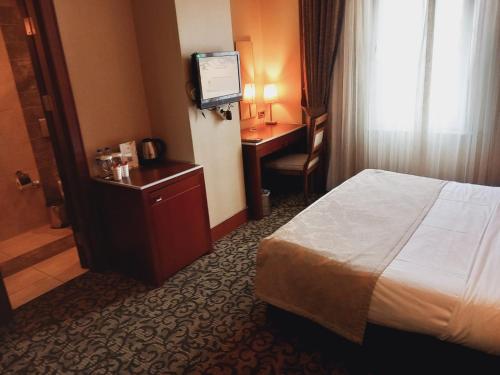 um quarto de hotel com uma cama e uma televisão em Dream Hill Business Deluxe Hotel Asia em Istambul
