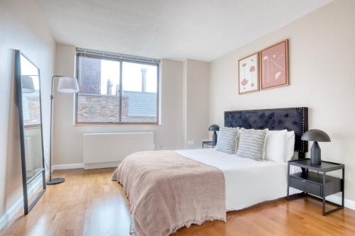 a bedroom with a large white bed and two windows at UWS 1br w gym doorman elevator nr Central Park NYC-1048 in New York