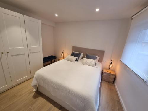 a bedroom with a white bed and a window at Apartamento centro Santander in Santander