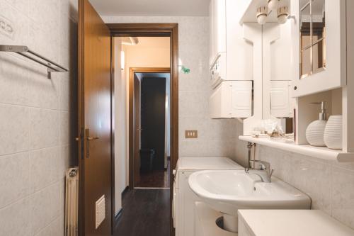a white bathroom with a sink and a mirror at [Piazza Goldoni] Suite Mazzini *Free WiFi* in Trieste