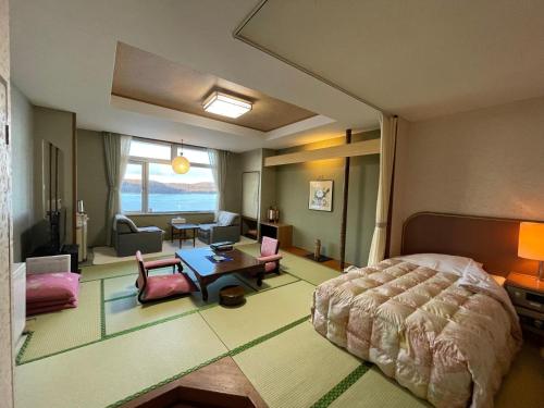 a bedroom with a bed and a living room at Hotel Abashirikoso in Abashiri