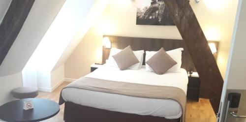 パリにあるオテル マザグランのベッドルーム1室(大型ベッド1台、白いシーツ、枕付)