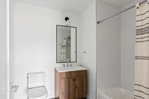 a bathroom with a sink and a toilet and a mirror at Hoboken 2br w wd gym nr light rail NYC-946 in Hoboken