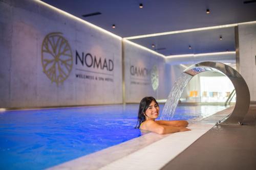 Eine Frau liegt im Pool in der Unterkunft Hotel Nomad in Bjelašnica