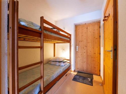 - une chambre avec 2 lits superposés et une porte dans l'établissement Les Eterlous 25 - Appt vue pistes 4 pers, à Morillon