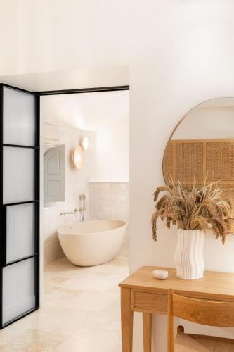 a bathroom with a tub and a large mirror at Le Couvent des Minimes, un Hôtel & Spa L'Occitane en Provence in Mane