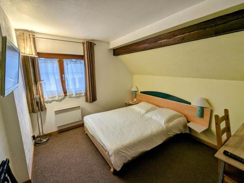 1 dormitorio con cama, mesa y ventana en Hotel le Chasseur, en Illkirch-Graffenstaden