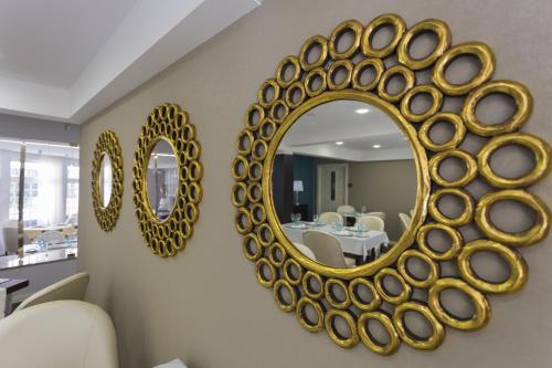 a large gold mirror on a wall in a living room at Josefa D`Obidos Hotel in Óbidos