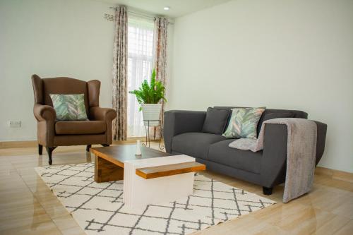 sala de estar con sofá y 2 sillas en Divine Heights Apartments Lilongwe Area 43, en Lilongwe