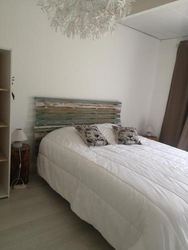 - un lit blanc avec deux oreillers dans une chambre dans l'établissement gite, à Illats