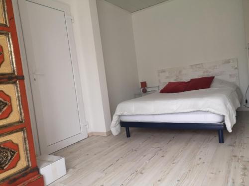 1 dormitorio con 1 cama con sábanas blancas y almohadas rojas en gite, en Illats