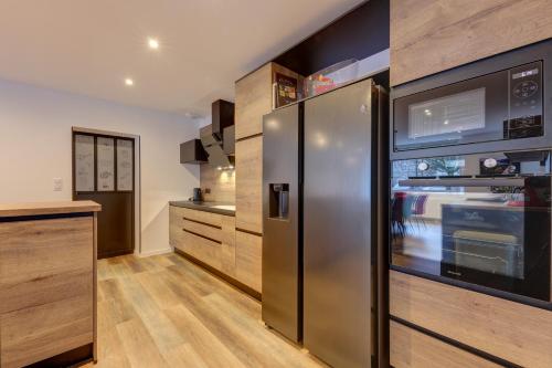 a kitchen with a stainless steel refrigerator at La Marionnade - Maison de village, Sauna, Balnéothérapie, Borne VE in Cerdon