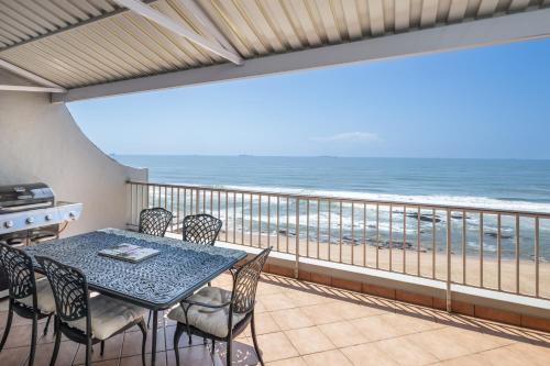 d'un balcon avec une table et des chaises donnant sur l'océan. dans l'établissement 22 Bronze Bay - by Stay in Umhlanga, à Durban