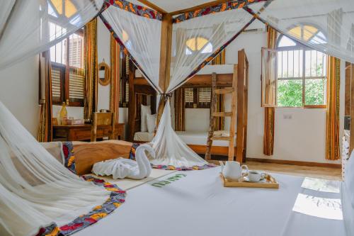 - une chambre avec un lit à baldaquin dans l'établissement Shoki Shoki House Stone Town, à Zanzibar City