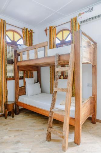 a room with two bunk beds and a ladder at Shoki Shoki Hotel Stone Town in Zanzibar City