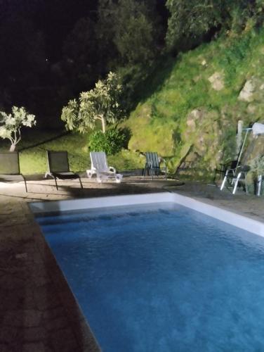 a large blue swimming pool with two chairs and a table at Quinta Viela Principal in Viseu