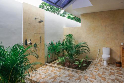 y baño con ducha, aseo y plantas. en Villa 10 Rose Bali 3BR Luxury en Ungasan