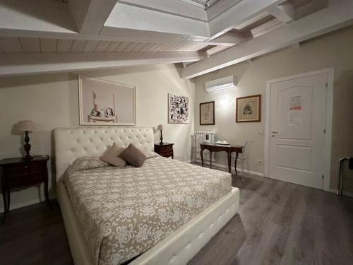 1 dormitorio con cama blanca y mesa en Villa Abbamer, en Grottaferrata