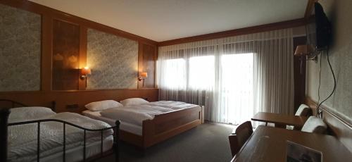 a hotel room with two beds and a window at Hotel Waldblick in Donaueschingen