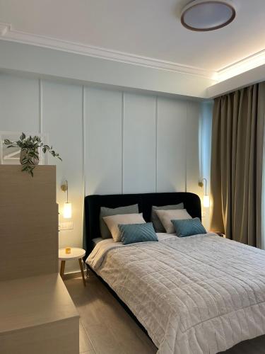 a bedroom with a large bed with blue pillows at Syntagma Hideaway Luxury Apt in Athens
