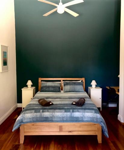 a bedroom with a large bed with a green wall at Clare to Spalding character escape in Spalding