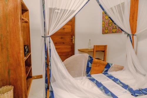 a bed with a canopy in a room at Shoki Shoki Hotel Stone Town in Zanzibar City