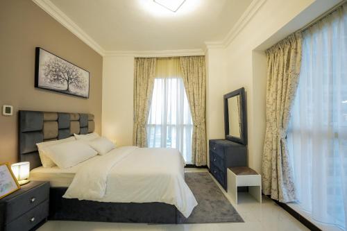 a bedroom with a large bed and a window at One Bedroom Apartment at MAG214 JLT by ANW Vacation Homes in Dubai