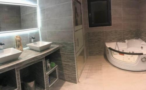 une salle de bain avec deux lavabos et une baignoire dans l'établissement Maison agréable et paisible, à Carcassonne