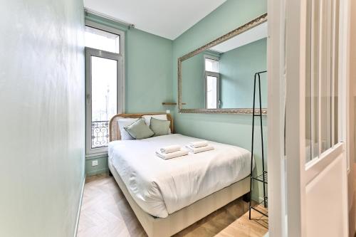 - une petite chambre avec un lit et un miroir dans l'établissement Appartement proche Parc Monceau - II, à Paris