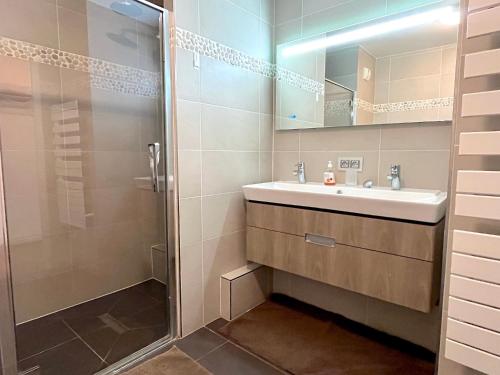 une salle de bain avec un lavabo et une douche dans l'établissement le Penthouse des Batignolles, à Paris
