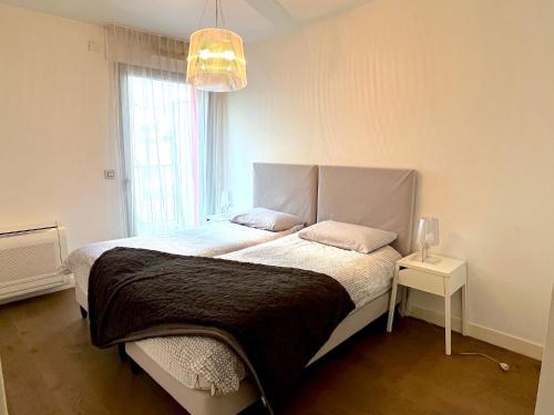 une chambre avec un grand lit et une fenêtre dans l'établissement le Penthouse des Batignolles, à Paris