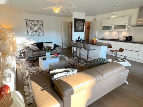 un salon avec un canapé et une cuisine dans l'établissement le Penthouse des Batignolles, à Paris