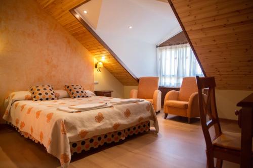 1 dormitorio con 1 cama y sillas en una habitación en Casa Rural Portal de Numancia ll en Garray