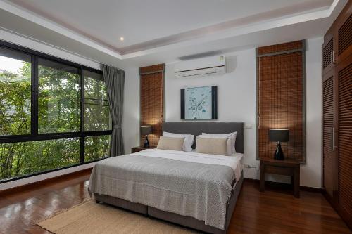 - une chambre avec un grand lit et de grandes fenêtres dans l'établissement Villa Decor, à Mae Nam Beach