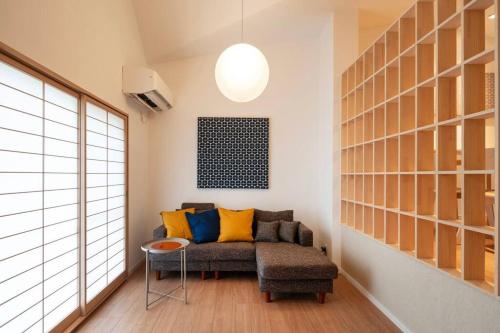 a living room with a couch and a table at 『花の影』カップル、ご友人、ご家族利用完全貸切!広々テラス露天風呂付!ポーラ美術館徒歩5分 in Hakone