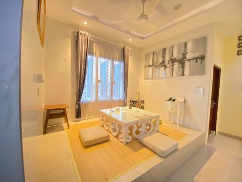 ein Wohnzimmer mit einem weißen Tisch und Stühlen in der Unterkunft JIYO BOUTIQUE HOTEL by SAJIWA in Medan