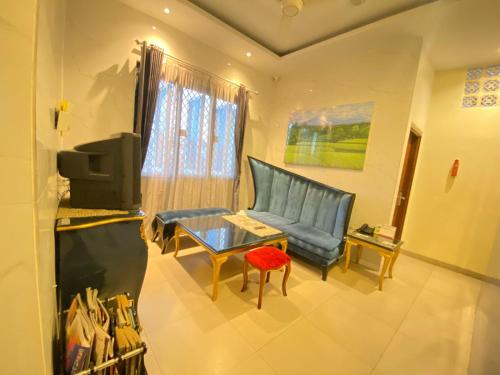 a living room with a couch and a table at JIYO BOUTIQUE HOTEL by SAJIWA in Medan