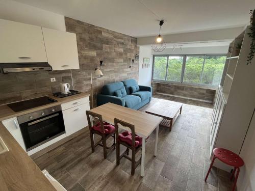 - une cuisine et un salon avec un canapé bleu et une table dans l'établissement Climatisation, connexion fibre, au cœur des Sablettes, tout à pied..., à La Seyne-sur-Mer