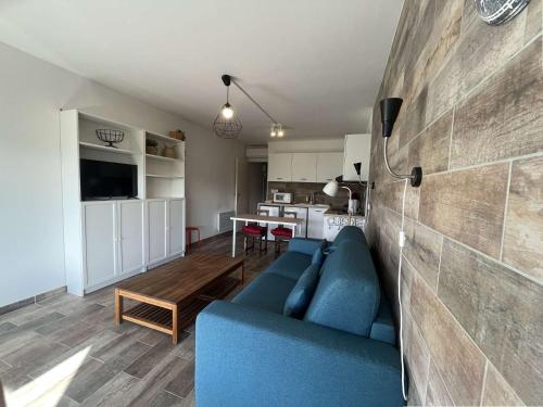 un salon avec un canapé bleu et une cuisine dans l'établissement Climatisation, connexion fibre, au cœur des Sablettes, tout à pied..., à La Seyne-sur-Mer