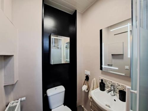 une salle de bain avec des toilettes blanches et un lavabo dans l'établissement Appartement Cosy, à Reims