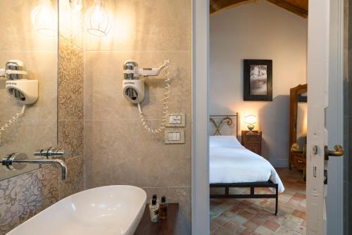 a bathroom with a tub and a sink and a bedroom at Casa Arrigo in Linguaglossa